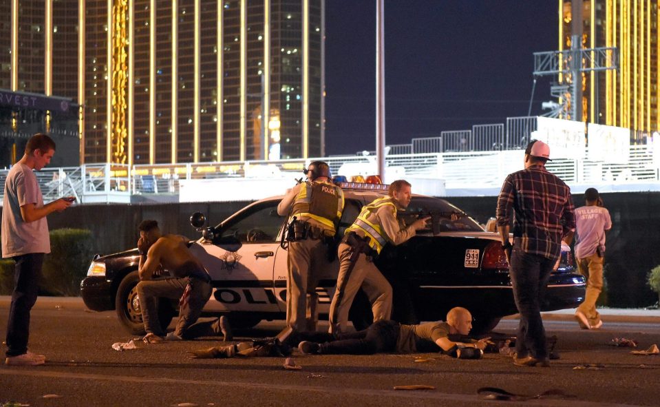 Armed cops cower behind a car