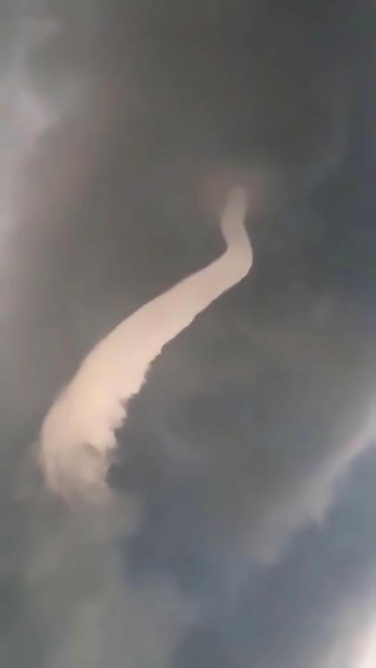  Footage shows the funnel cloud snaking down from a sky full of dark grey clouds