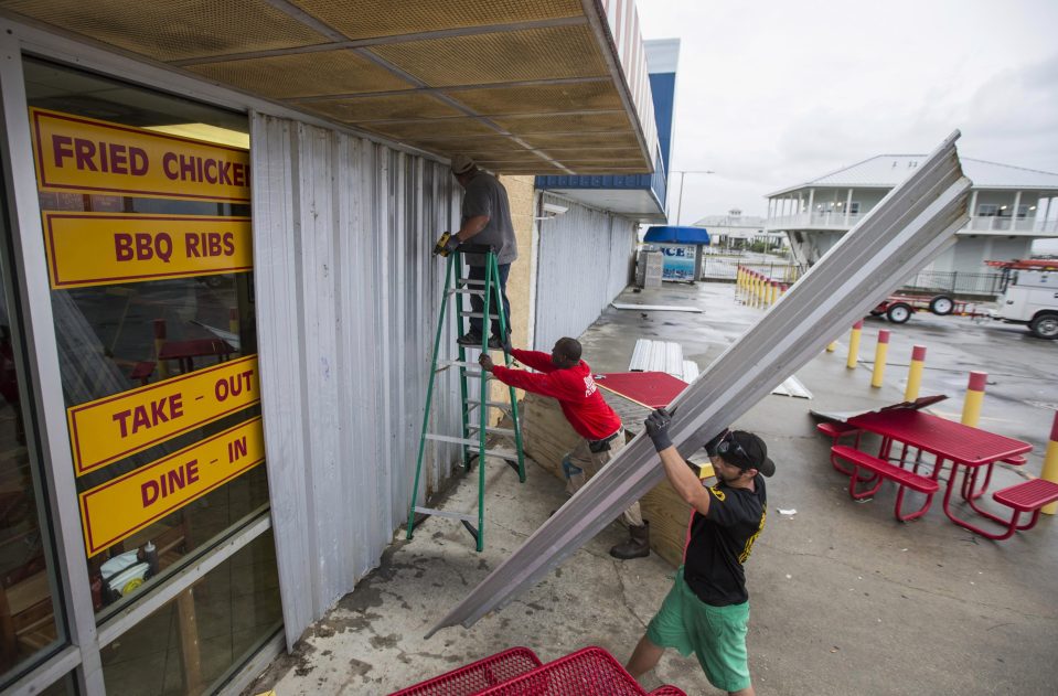 Charles Jackson, front, Immanuel Hubbard, center and Rober Butler board up Mother Cluckers at the Pass Christian Port Harbor Marina as Hurricane Nate approaches the northern Mississippi Gulf Coast