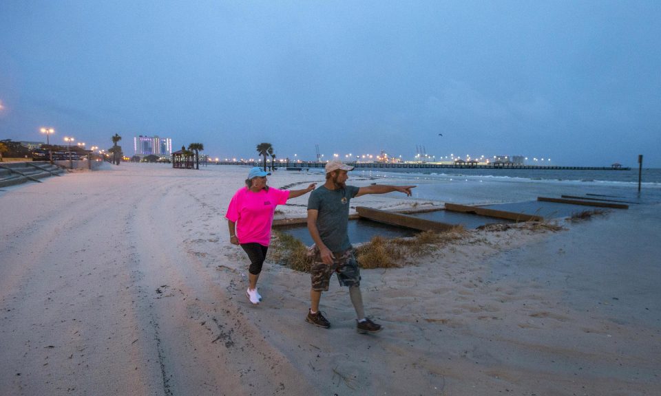  Residents Kevin and Stacy Marlow, from Vaiden, Mississippi, search for driftwood on the beach ahead of the arrival of Hurricane Nate as night falls in Gulfport