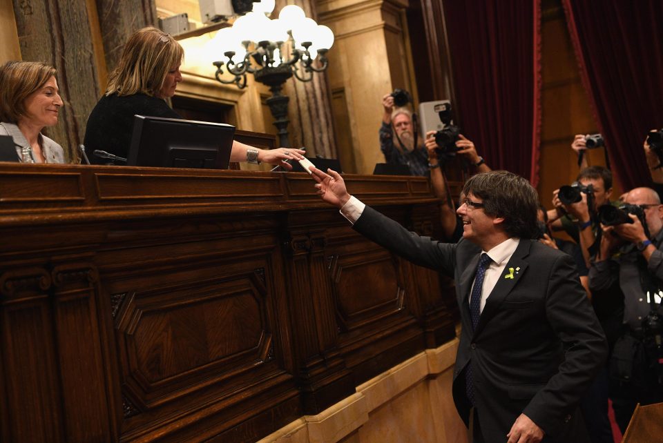 Catalan President Carles Puigdemont is seen handing in his ballot paper on Friday