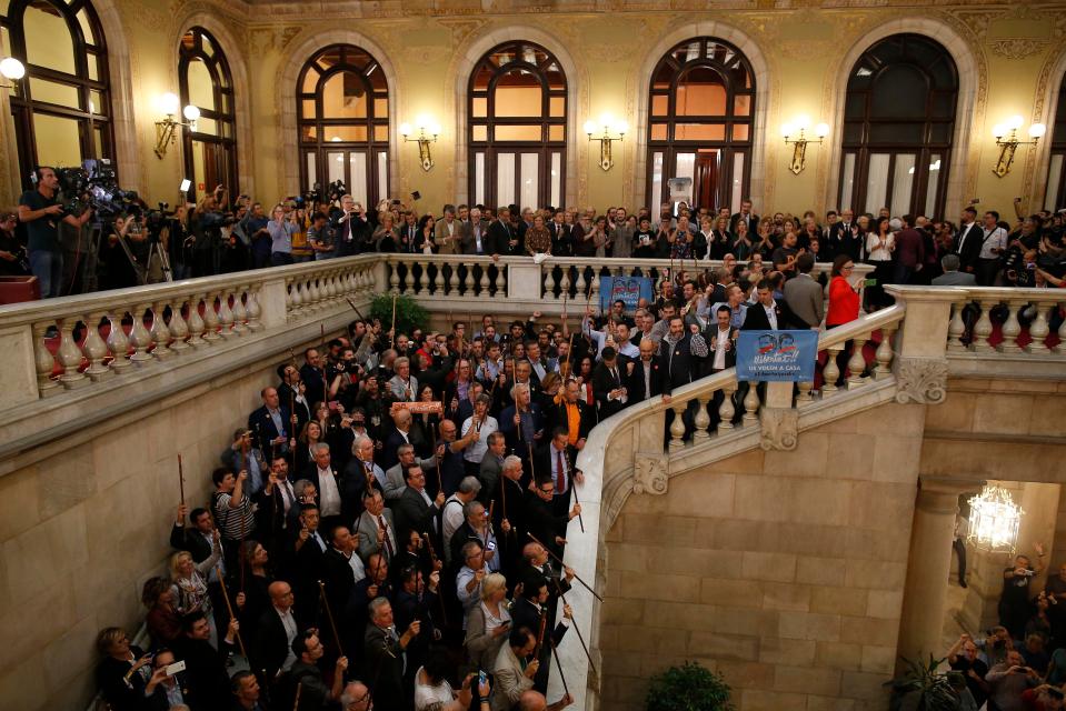  Separatist lawmakers hold their ceremonial staves into the air after a vote on independence in the Catalan parliament in Barcelona