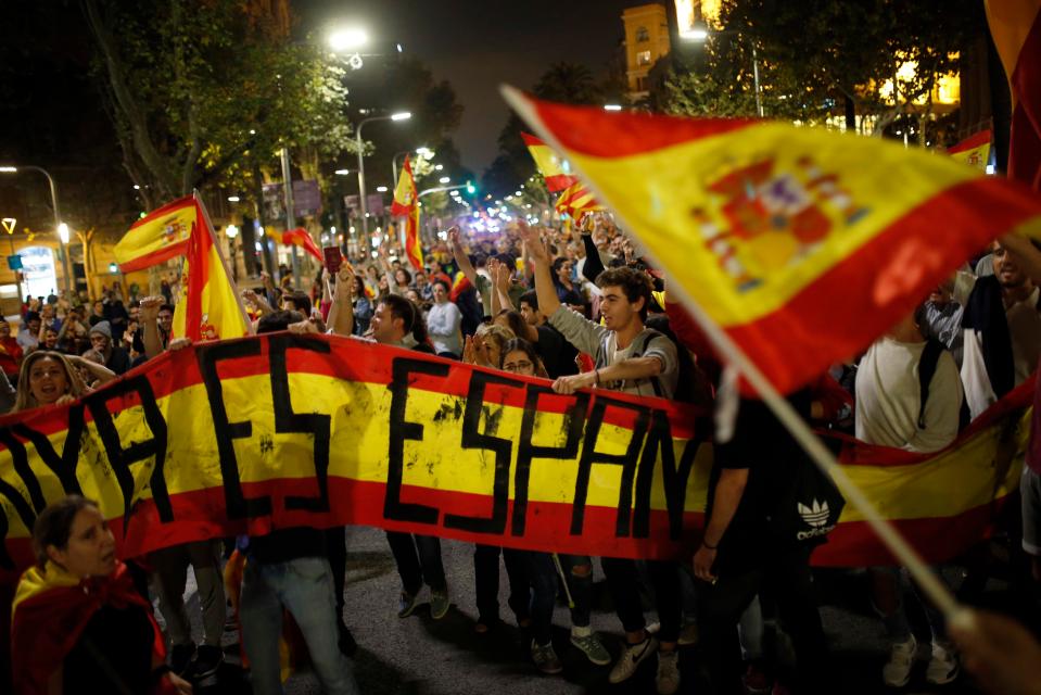Anti-independence supporters shout slogans and wave Spanish flags as they march against the unilateral declaration of independence 