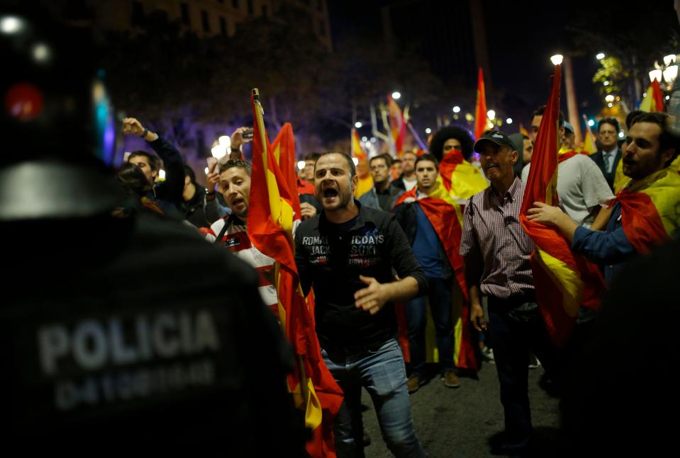 A demonstrator confronts Catalan riot police 