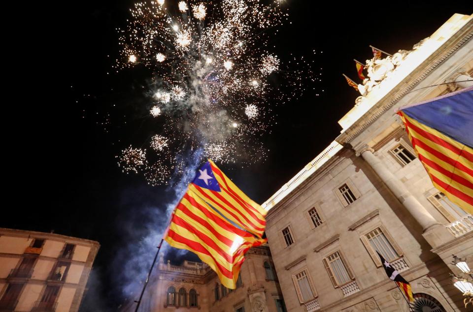  Catalan flags are held up as fireworks go off in Sant Jaume Square in front of the Catalan regional government in Barcelona