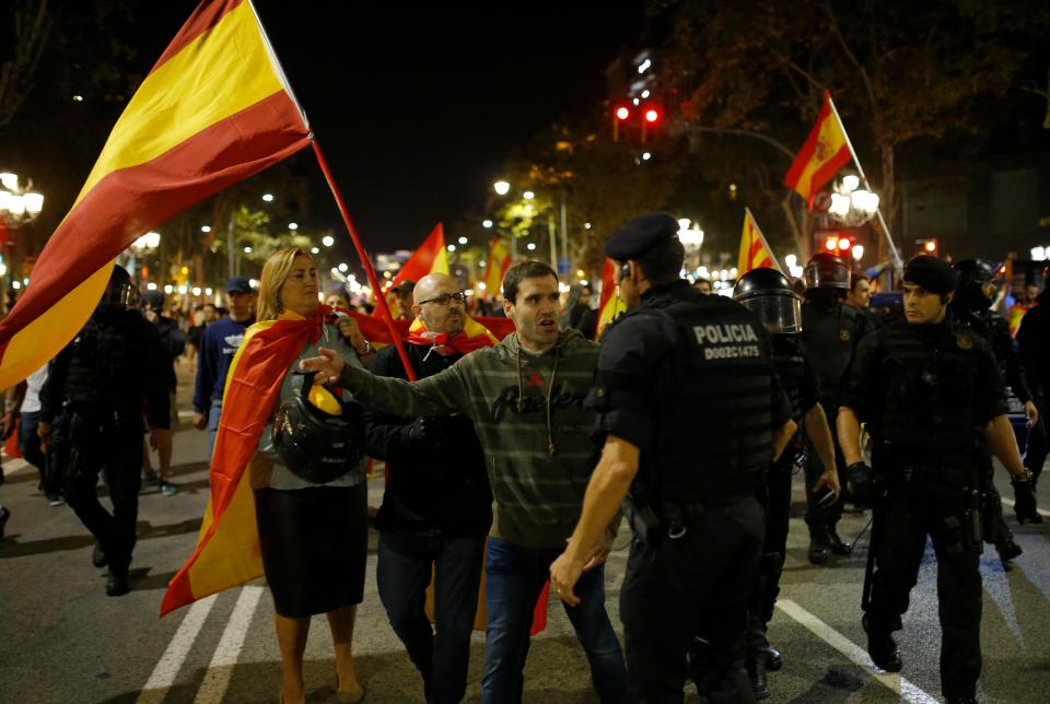  Spanish protesters wave flags as riot police look on in Barcelona