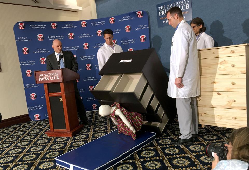 Consumer Product Safety Commission employees watch as a dummy falls over and under IKEA's Malm model chest of drawers in June 2016