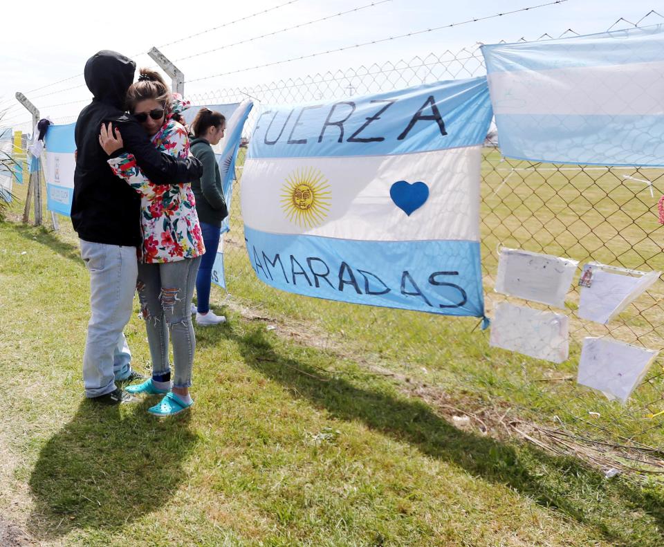  People attach Argentine flags, religious icons and messages to the fence of the Mar del Plata naval base
