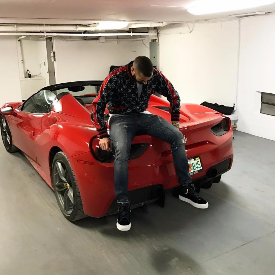  Karim Benzema poses on a Ferrari in a Gucci bomber jacket