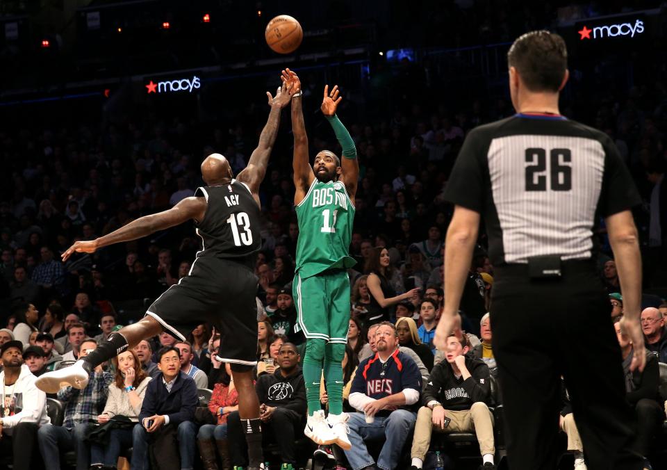 Kyrie Irving gets off a three-point attempt for Boston