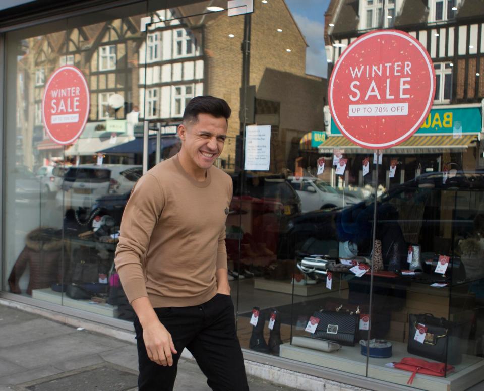 Alexis Sanchez hit the streets of North London for a haircut on Wednesday... walking past a 'Winter Sale' sign