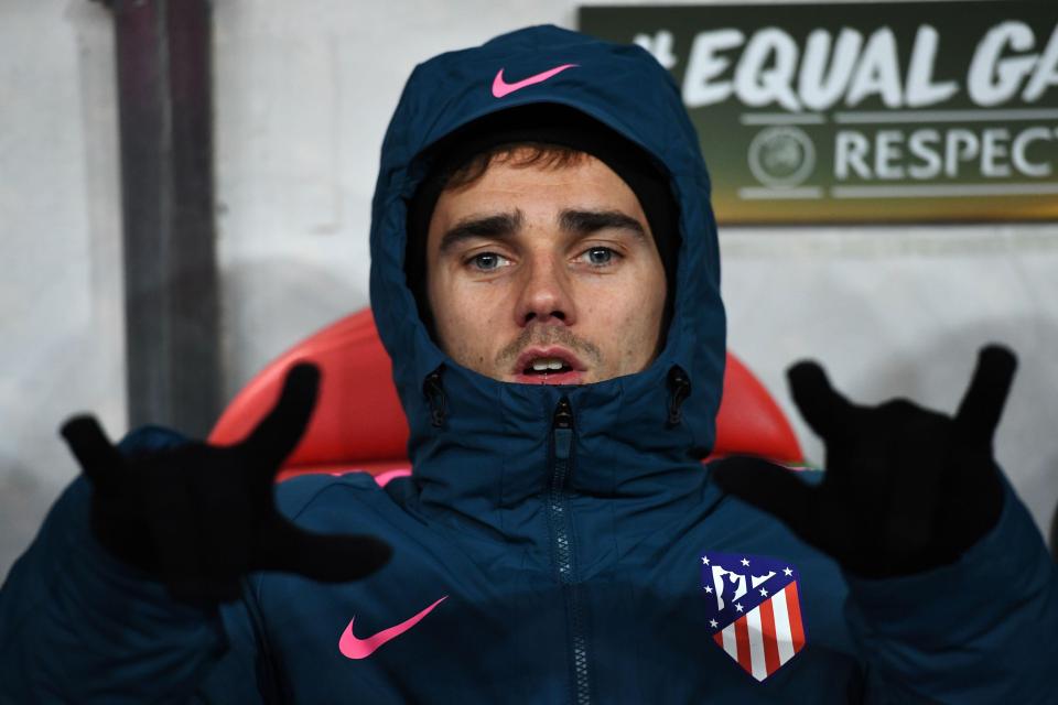 Antoine Griezmann keeps warm on the bench before entering the fray
