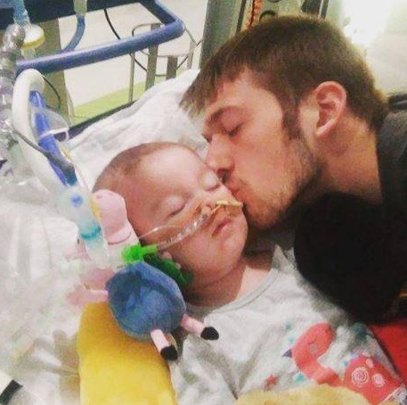 Dad Tom Evans kisses his son Alfie in this photo shared by the family online