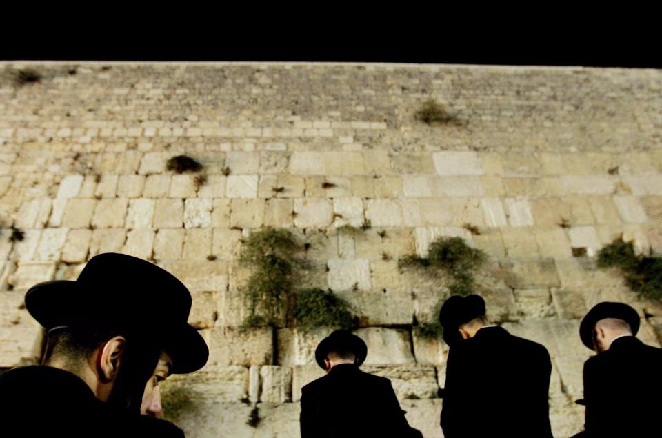 Ultra-orthodox Jewish men pray at the floodlit Western Wall, Judaism's holiest site, before the holiday of Yom Kippur, in Jerusalem