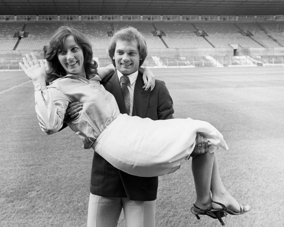 Ray Wilkins lifts his wife, Jackie, aloft after signing for Manchester United