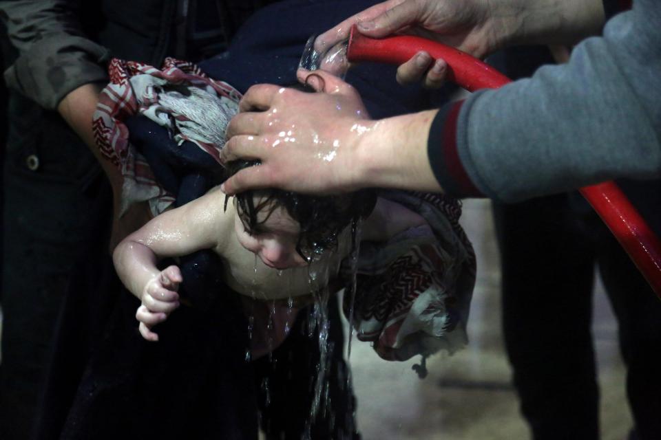 A child is showered as part of a rudimentary decontamination process 