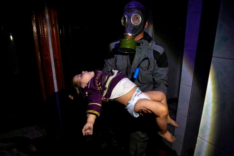 This rescuer carries a stricken toddler from a home