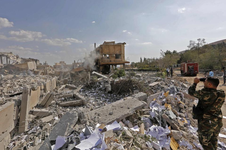  A Syrian solider takes a picture of the ruin that was suspected to be a chemical weapons facility