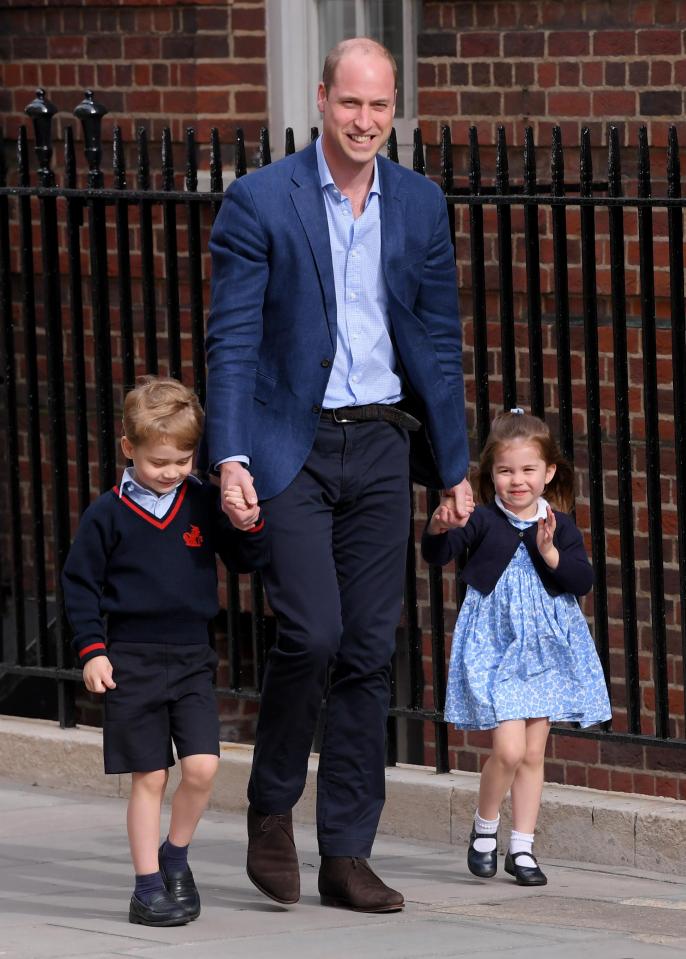 Prince William smiles as he takes his children in to meet their new baby brother