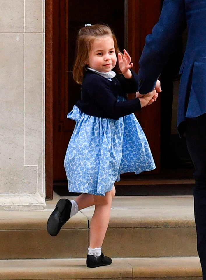 Prince Charlotte gives an adorable wave as she follows her dad and big brother into the hospital