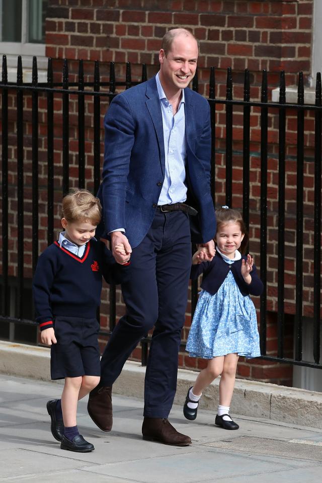 Prince George and Princess Charlotte hold dad Prince William's hand as they arrive at 