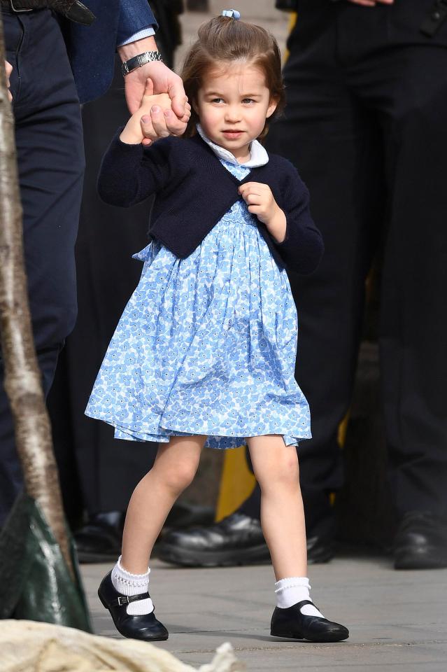 The royal toddler wore a floral blue dress with a navy cardigan and matching hairband on her way to hospital