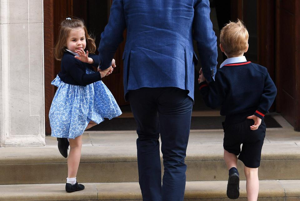 A confident Princess Charlotte waves back to the camera as she walks up the steps to the maternity ward 