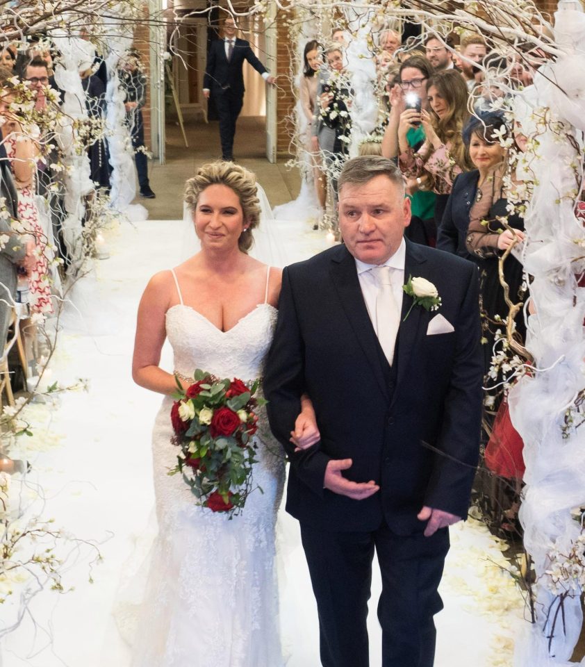  A smiling Brooke Kinsella, being walked down the aisle by her father George