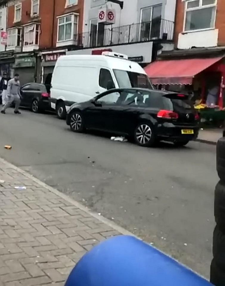  The black VW is seen driving towards the man and swerves in his direction