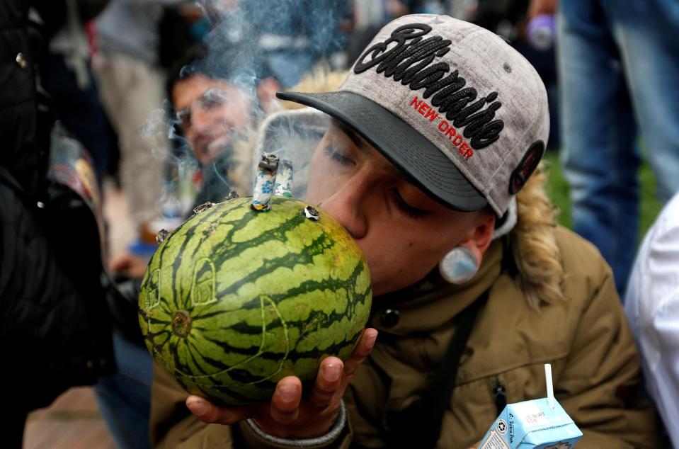  A man smokes up using a homemade melon bong