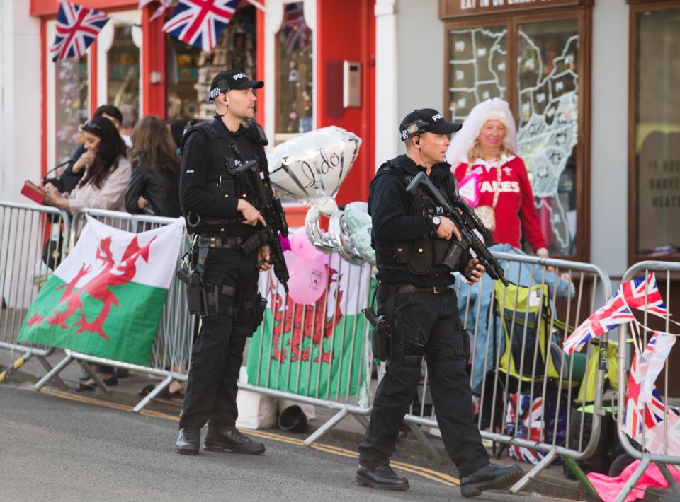 Police walk past royal fans who have already started to camp out in Windsor