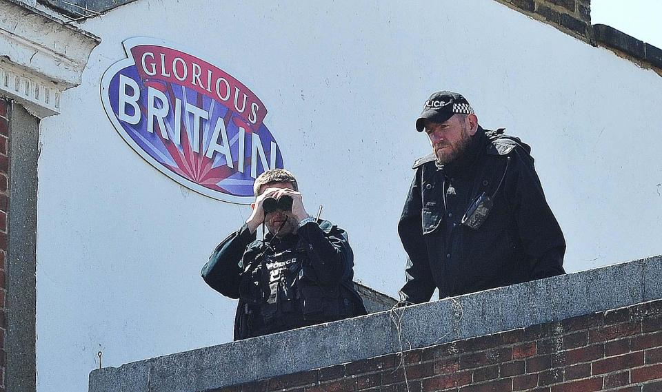 Two officers are seen on a roof above the crowds already starting to gather in Windsor for the wedding
