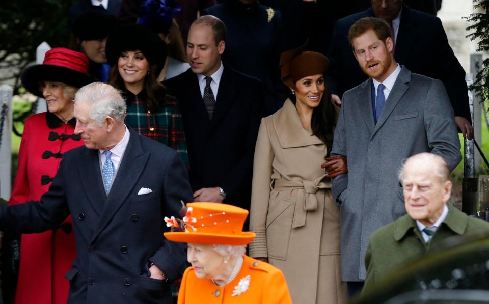 Meghan smiles as she stands near her future father-in-law