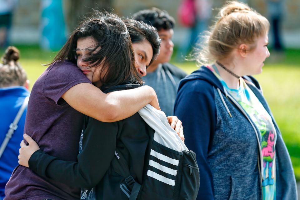  Shocked locals comfort each other after the atrocity