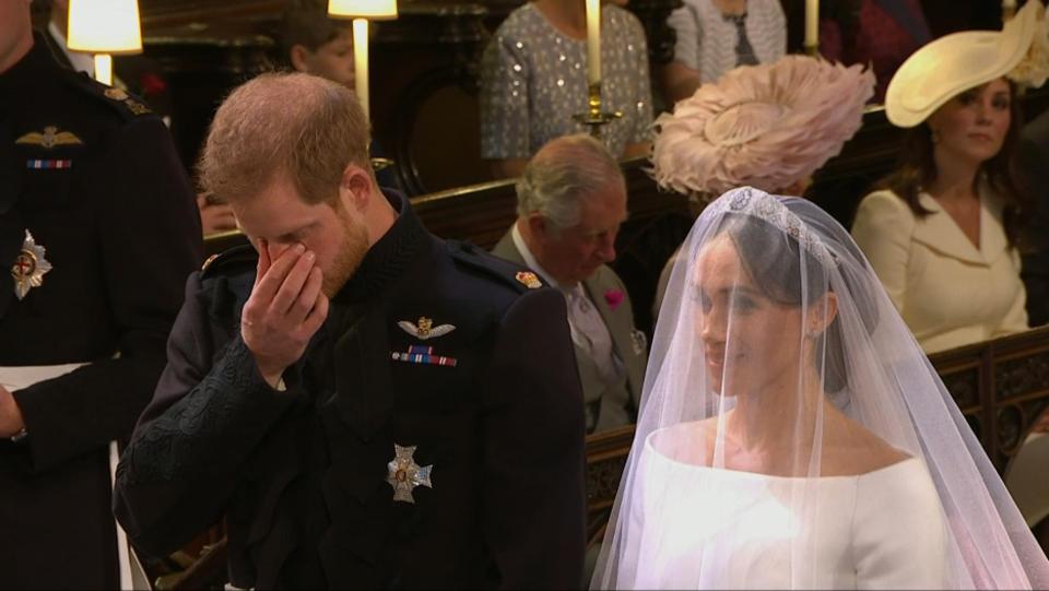 A visibly emotional Prince Harry appears to wipe away a tear during the service