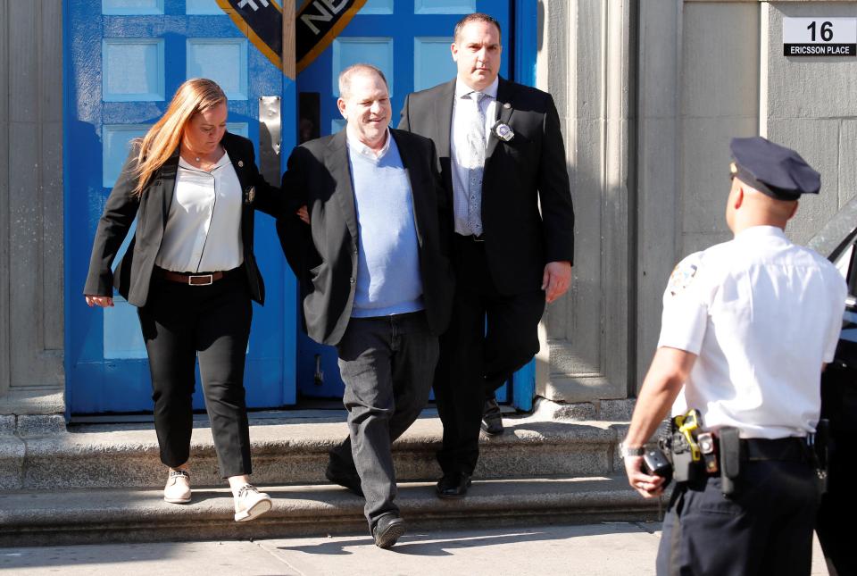 Harvey Weinstein is led out in cuffs after being charged with rape and sexual assault against two women