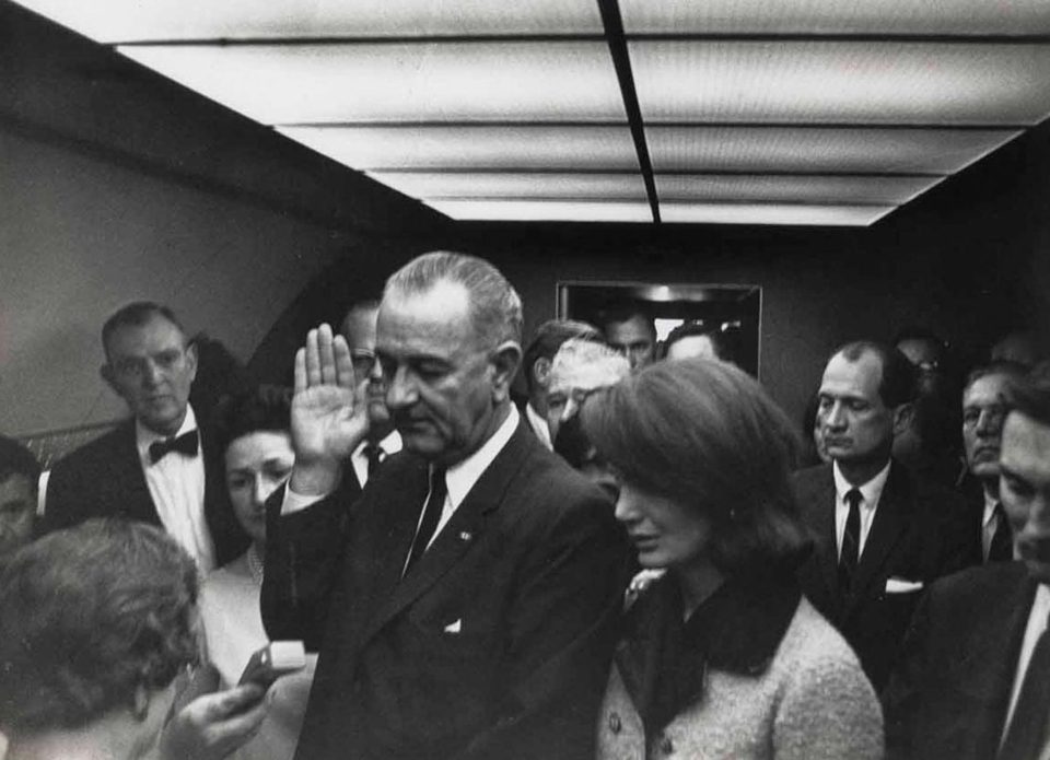 LBJ raises his right hand to be sworn in to take over the slain President 