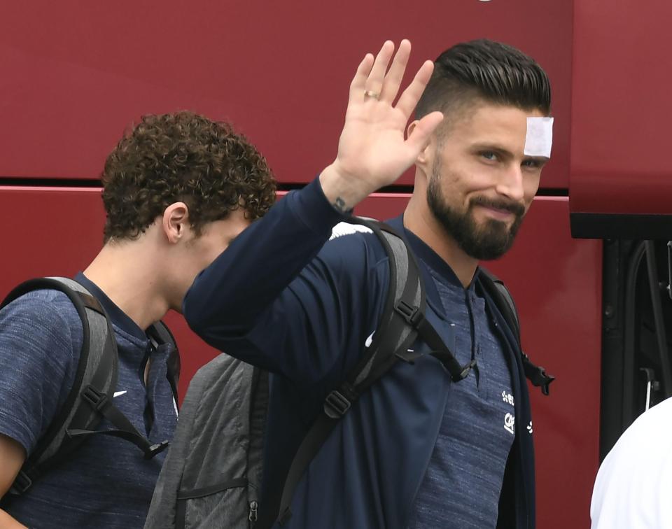  Olivier Giroud waved for the cameras as he boarded the plane with his France team-mates