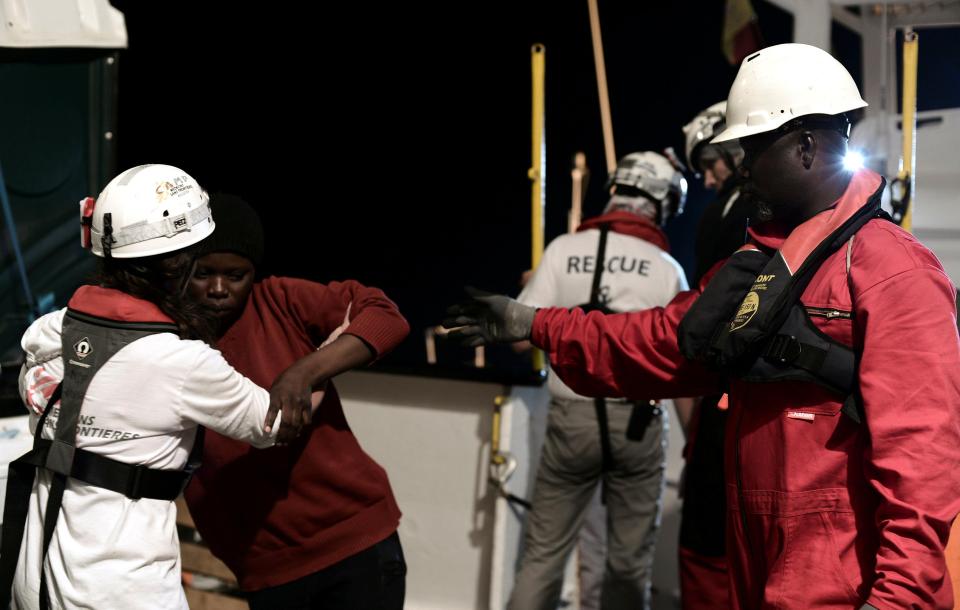 People are helped back on board the Aquarius after being picked up at sea 