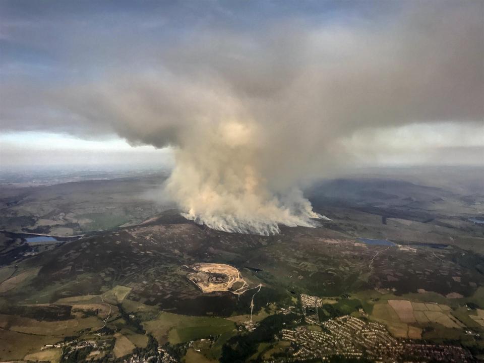 The devastation is seen this morning from high above as smoke continues to billow into the sky