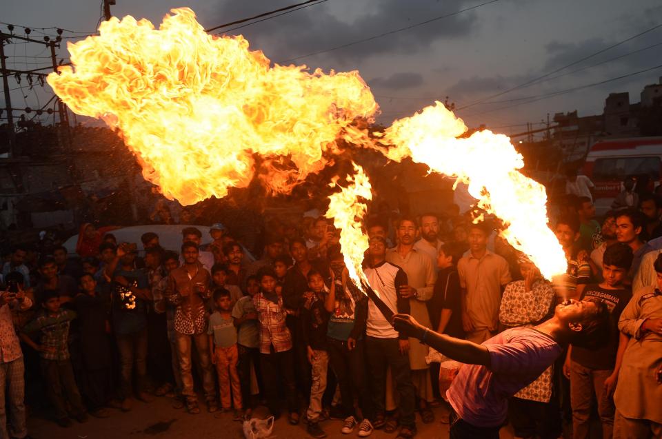 A Pakistani Sunni Muslim spits fire during an Ashura procession in Karachi
