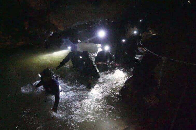 Thai navy seals wade through the flooded main passage way into the underground cave network 