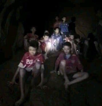 This extraordinary image shows the boys huddled up as the Brit cave divers come to the rescue