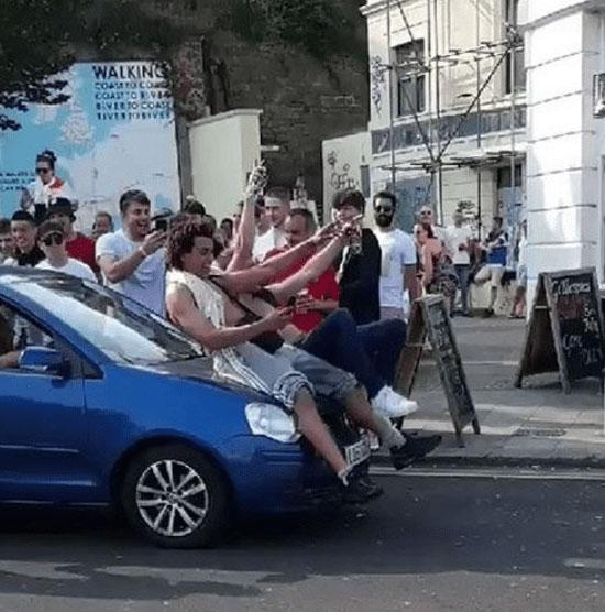  Two England fans were spotted riding on the bonnet of a car as it sped through streets in Folkestone, Kent