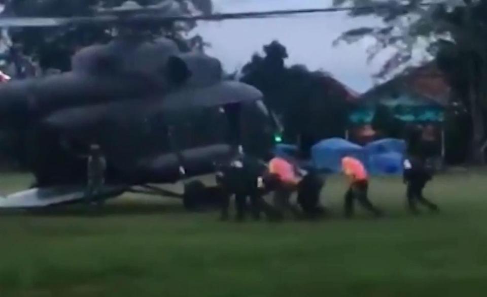  One of the boys is stretchered to a rescue chopper after they were saved by elite divers