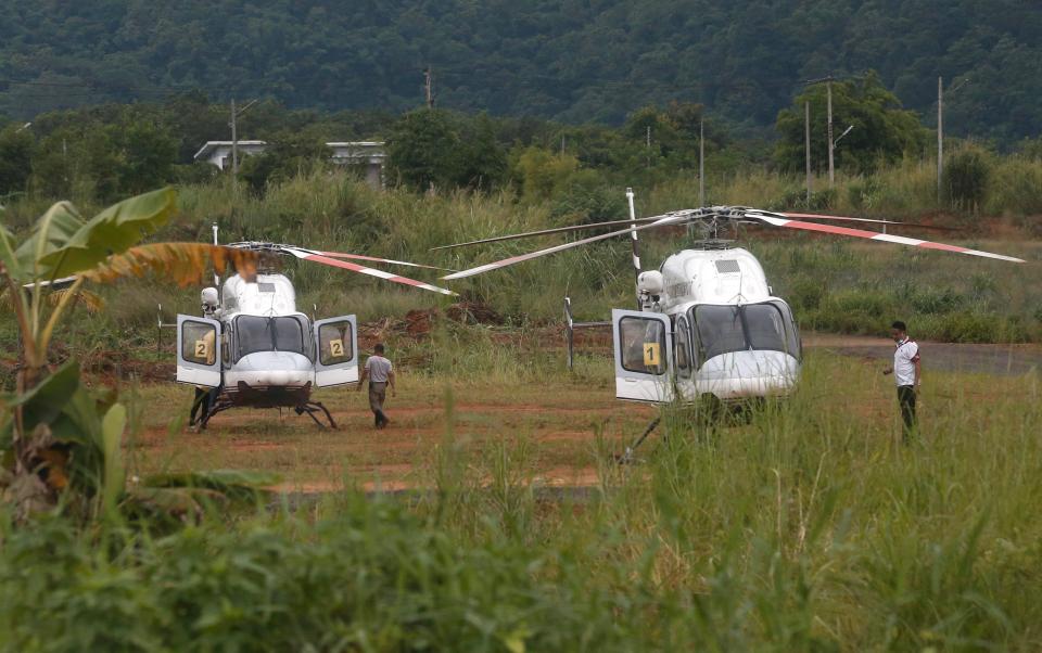  Two helicopters wait near the cave for more evacuations of the boys and their coach