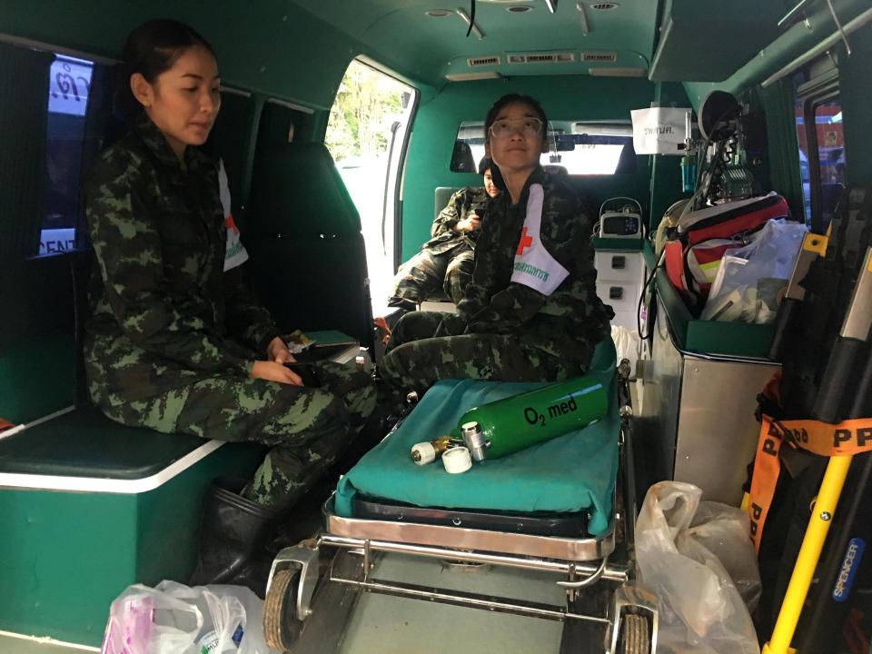  Medics wait in one of nine ambulances stationed outside the Tham Luang cave complex