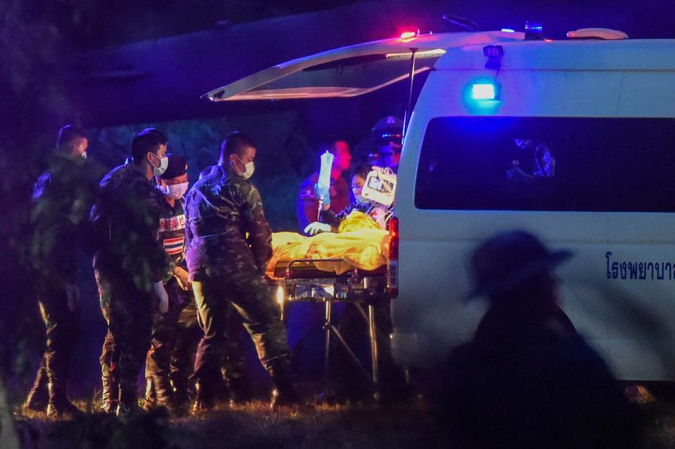  An emergency crew loads another rescued boy into an ambulance on Monday