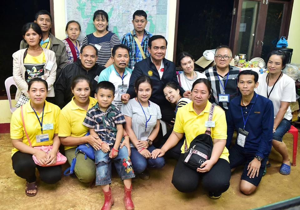  Prime Minister Prayut Chan-o-cha, middle, posing for a group photo with family members of the trapped boys