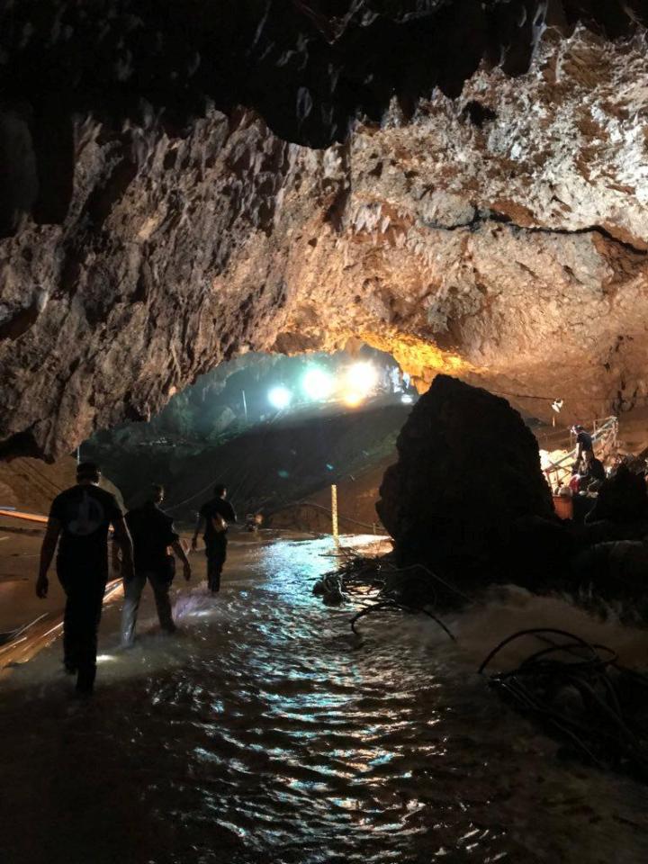  Floodlights and rescue workers seen at the mouth of the cave